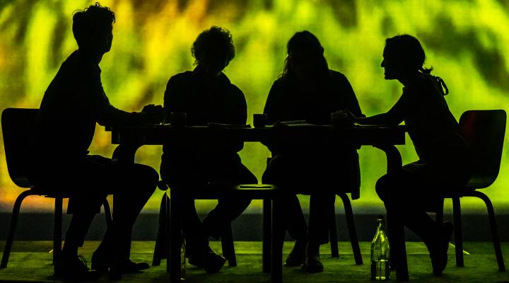 silhouette of 4 people sitting at a table