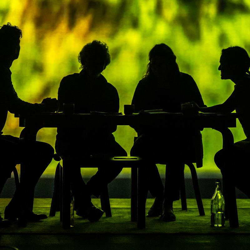 silhouette of 4 people sitting at a table